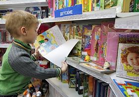 Магазин периодической печати компании 'Сейлс'. Ребенок с детским журналами у стеллажей