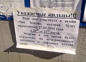 Жанровая фотография. Объявление: 'Ваш дом участвует в акции 'Час Земли', которая будет проводиться 27.03.2010 года с 20.30 до 21.30 часов. Энергия в это время будет отключена на незадымляемых лестницах и лифтовых холлах дома', на входной двери жилого дома