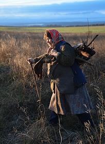 Пенсионерка собирает дрова для отопления дома